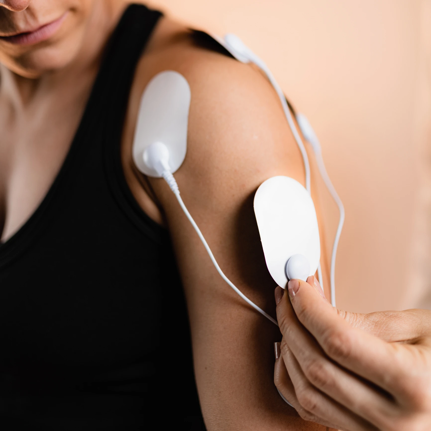 Person using electrode pads on arm.