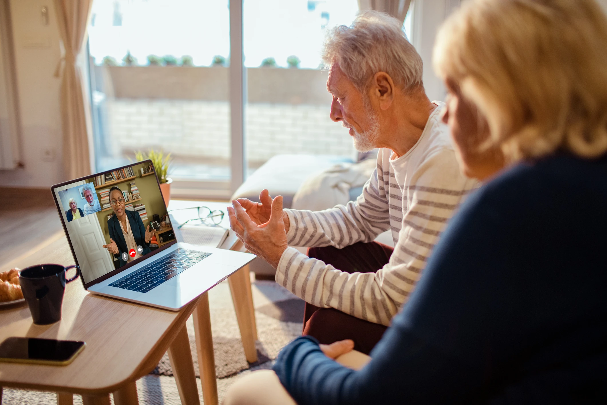 Elderly couple video chatting on laptop.