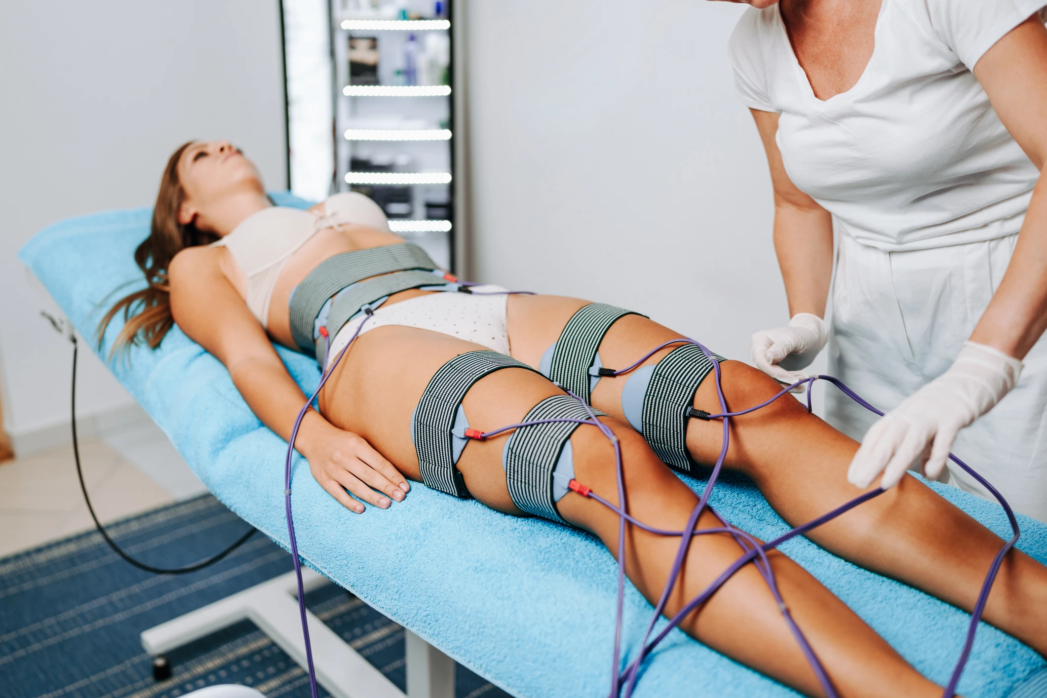 Woman receiving electrical muscle stimulation therapy.