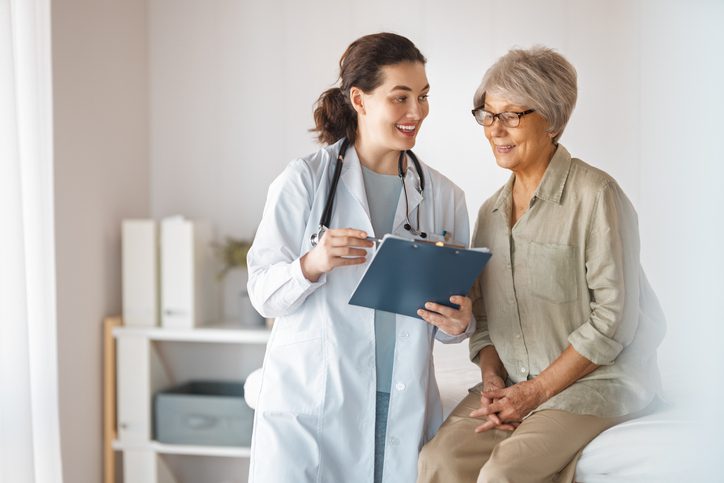 Doctor consulting with elderly patient in office.
