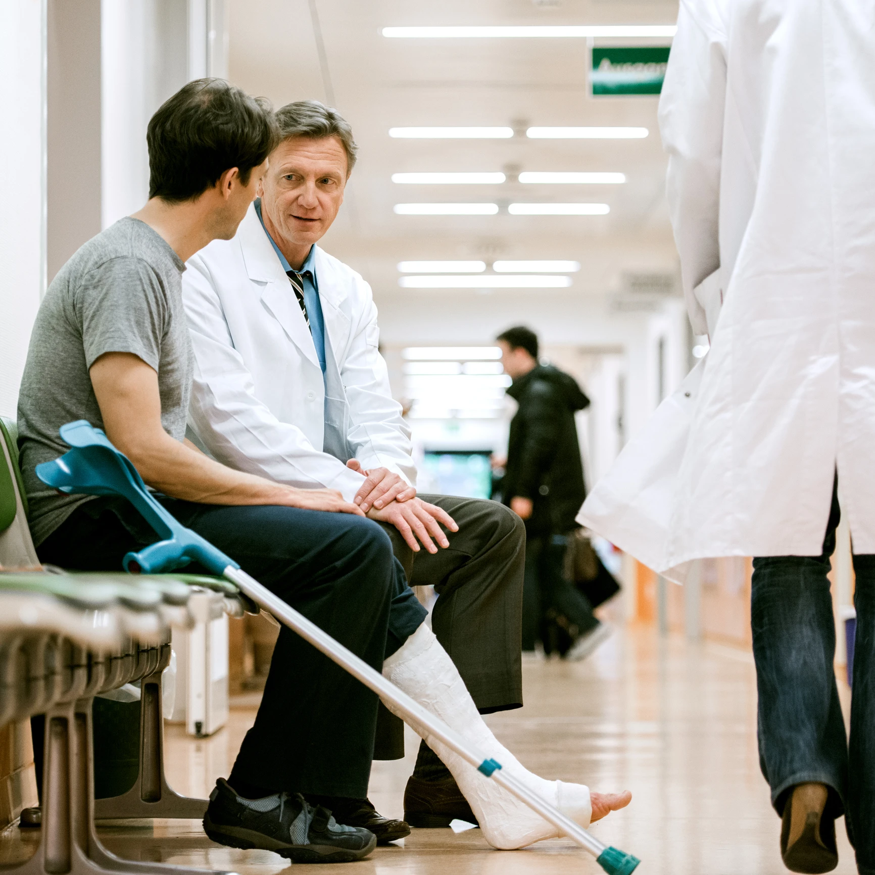 Patient with crutches talking to a doctor.