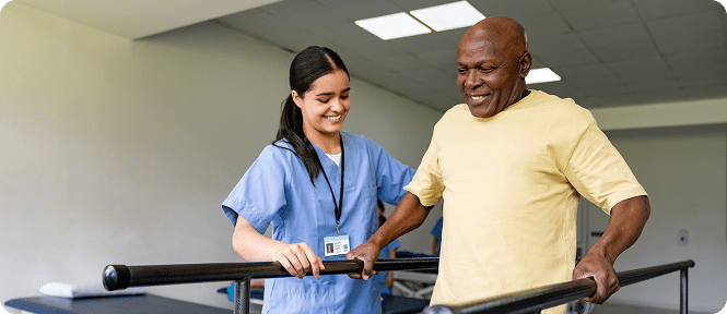 Elderly man assisted by healthcare worker walking.