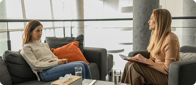 Two women talking in a modern office.
